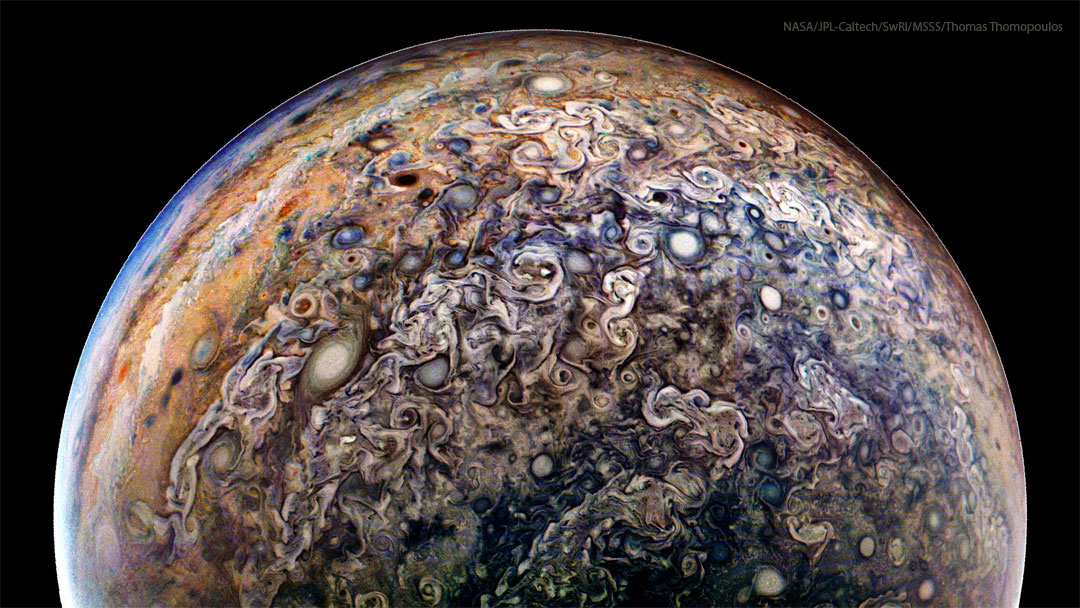 The planet Jupiter is shown from an unusual angle. Most
prominent are a miasma of jumbled and swirling clouds including
many oval storms. 
Please see the explanation for more detailed information.