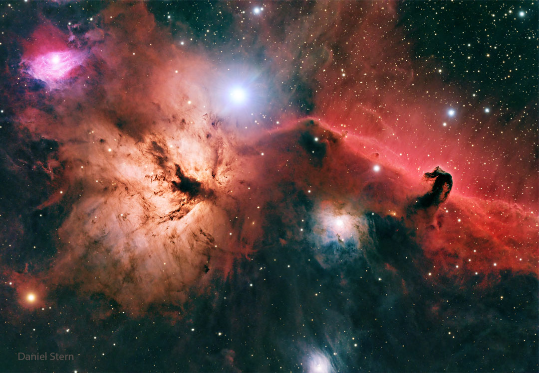 A starfield is shown with bright and dark nebulae of 
different shapes and colours.
Please see the explanation for more detailed information.