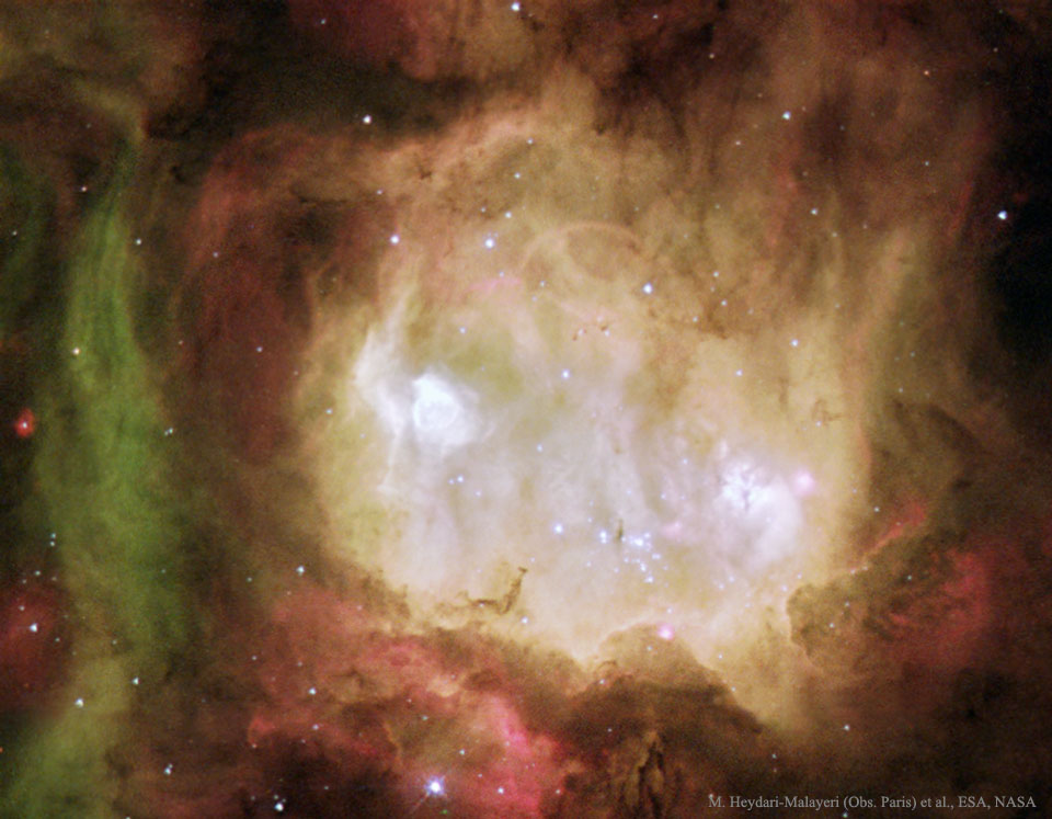 A white nebula appears in a colorful star field. To some,
the nebula appears like a ghost. 
Please see the explanation for more detailed information.