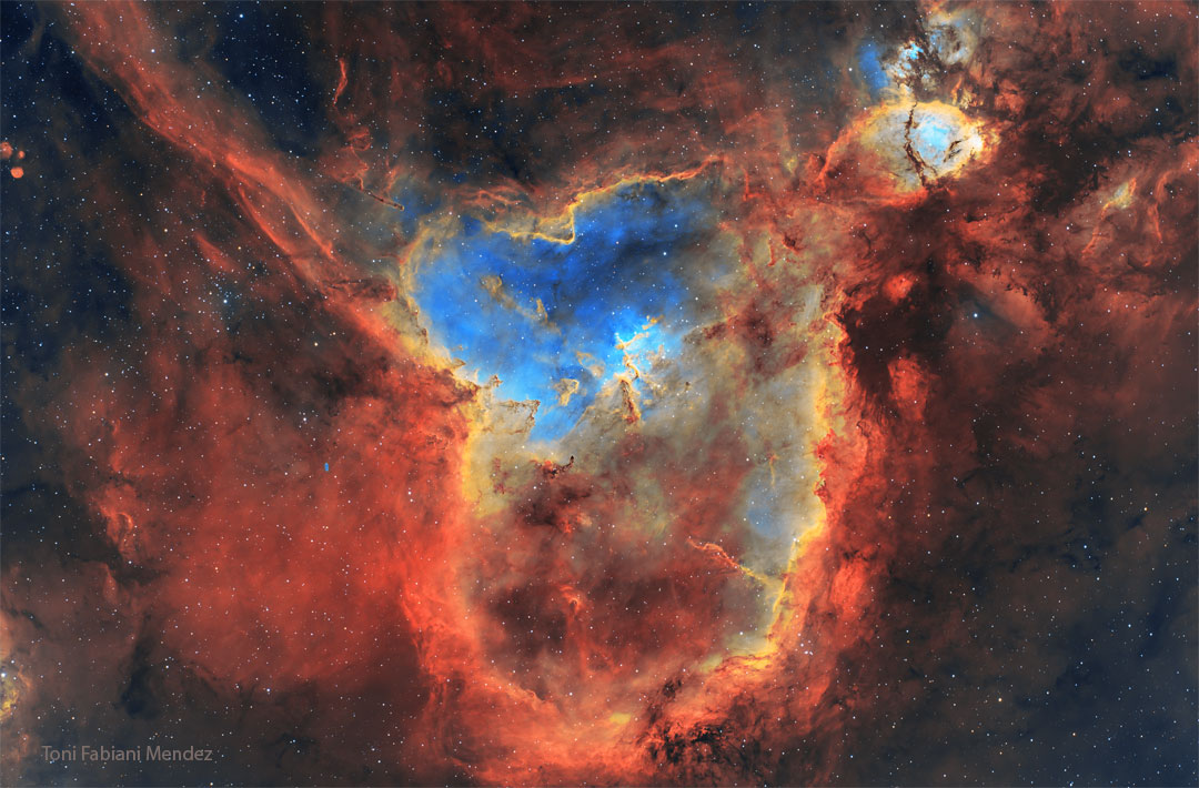 A starfield is shown filled with colourful gas glowing
in different colours, and dark dust.
Please see the explanation for more detailed information.