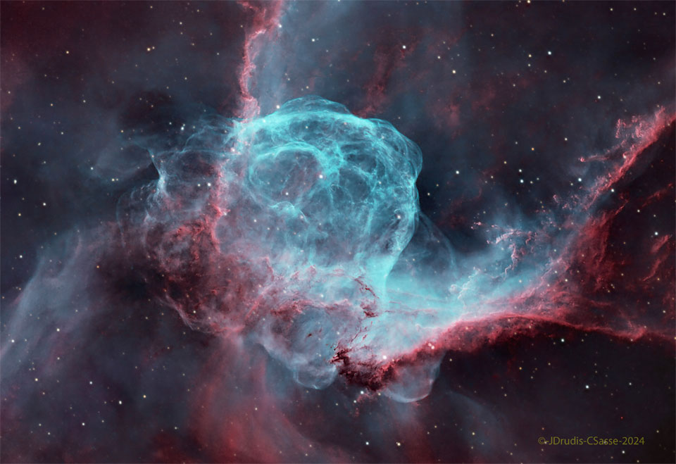 A starfield surrounds a complex nebula with many red
and blue filaments. Dark streams of dust also populate 
the nebula. 
Please see the explanation for more detailed information.